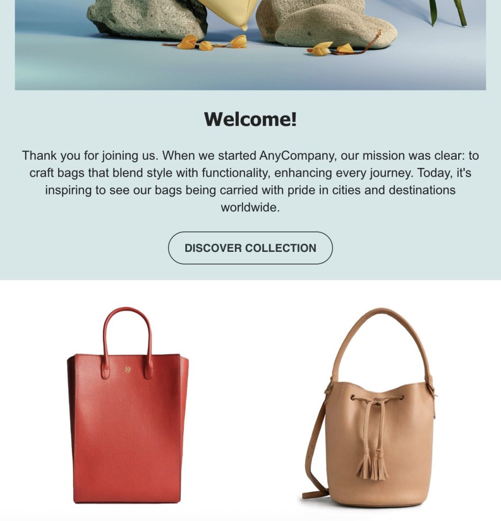 An image with a welcoming message and two bags. The top section shows a nature scene with rocks and a plant. Below, text reads: 'Welcome!' and a message about AnyCompany's mission to craft stylish and functional bags. A button labeled 'DISCOVER COLLECTION' is below the text. The bottom section displays two bags: a red tote bag on the left and a tan bucket bag with tassels on the right.